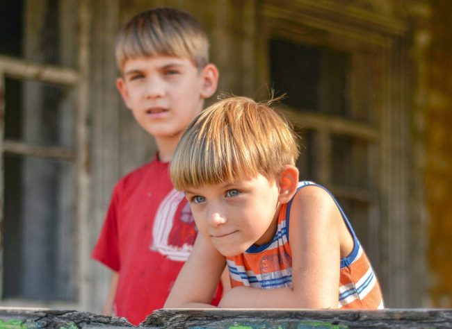 Children in a burnt house lost their homes as a result of hostilities and natural disasters.